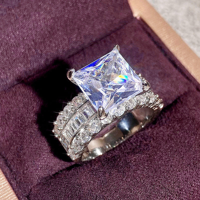 Zircon-inlaid geometric ring with large clear princess-cut center and textured pave sides