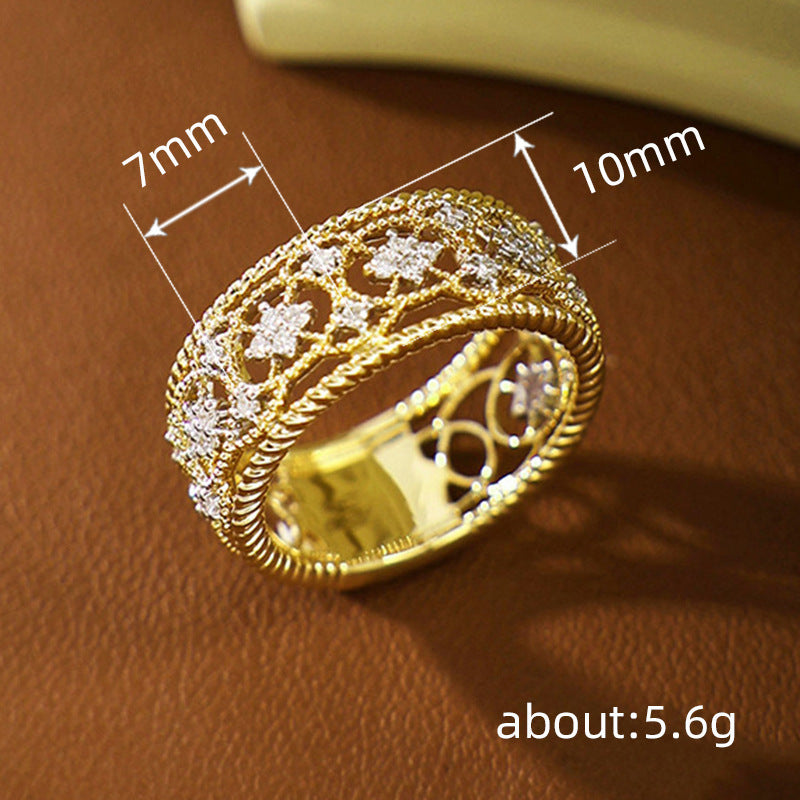 Gold-tone carved openwork ring with floral lattice cutouts and beaded side trim