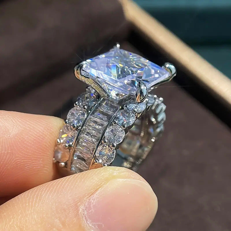 Zircon-inlaid geometric ring close-up on finger with faceted square center and pave accents