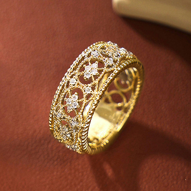 Gold-tone openwork ring featuring carved floral cutouts and beaded edge