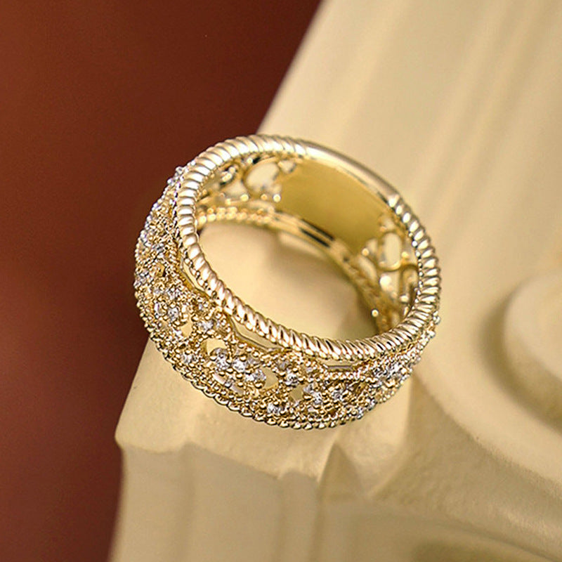 Gold-tone openwork band ring with beaded rim and sparkle-textured outer design