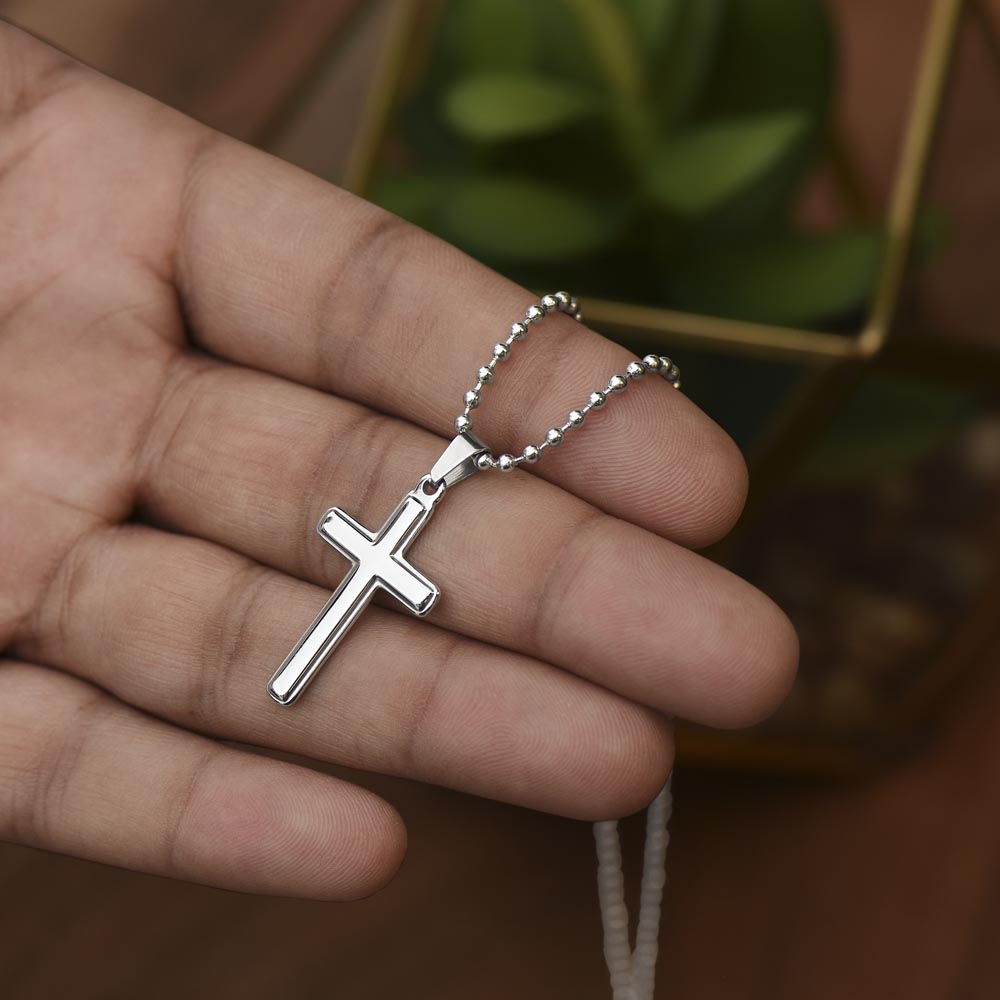 Silver cross pendant necklace with ball chain on a hand