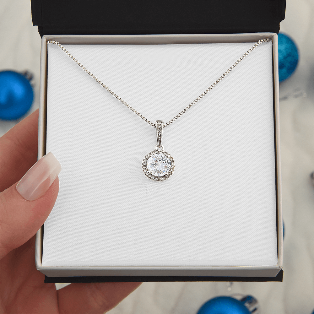 Round crystal halo pendant necklace on a thin silver-tone chain in a jewelry box
