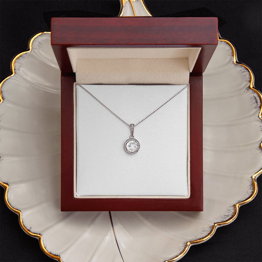 Round crystal halo pendant necklace in a red square jewelry box with hinged lid