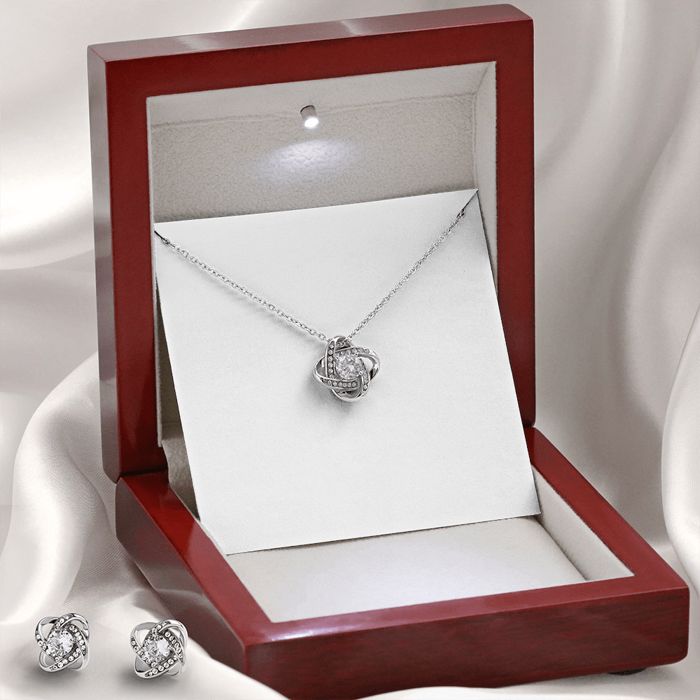 Silver-tone heart pendant necklace with matching stud earrings displayed in jewelry box