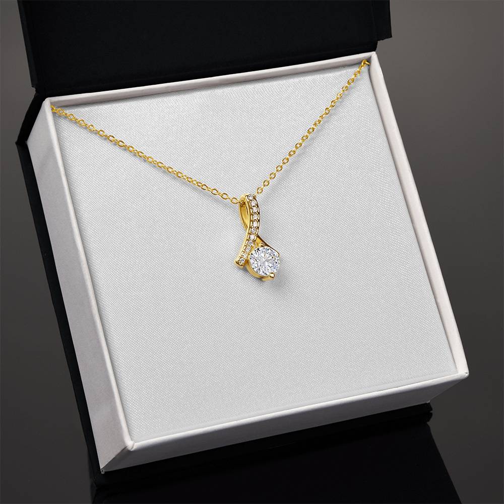 Yellow gold necklace with teardrop pendant and round clear gemstone, chain