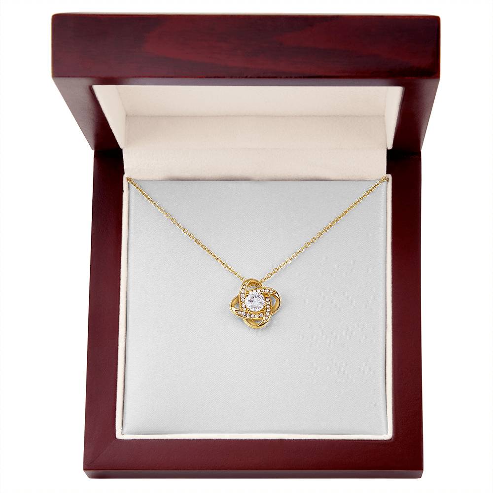 Love knot pendant necklace with round clear center stone on yellow gold chain