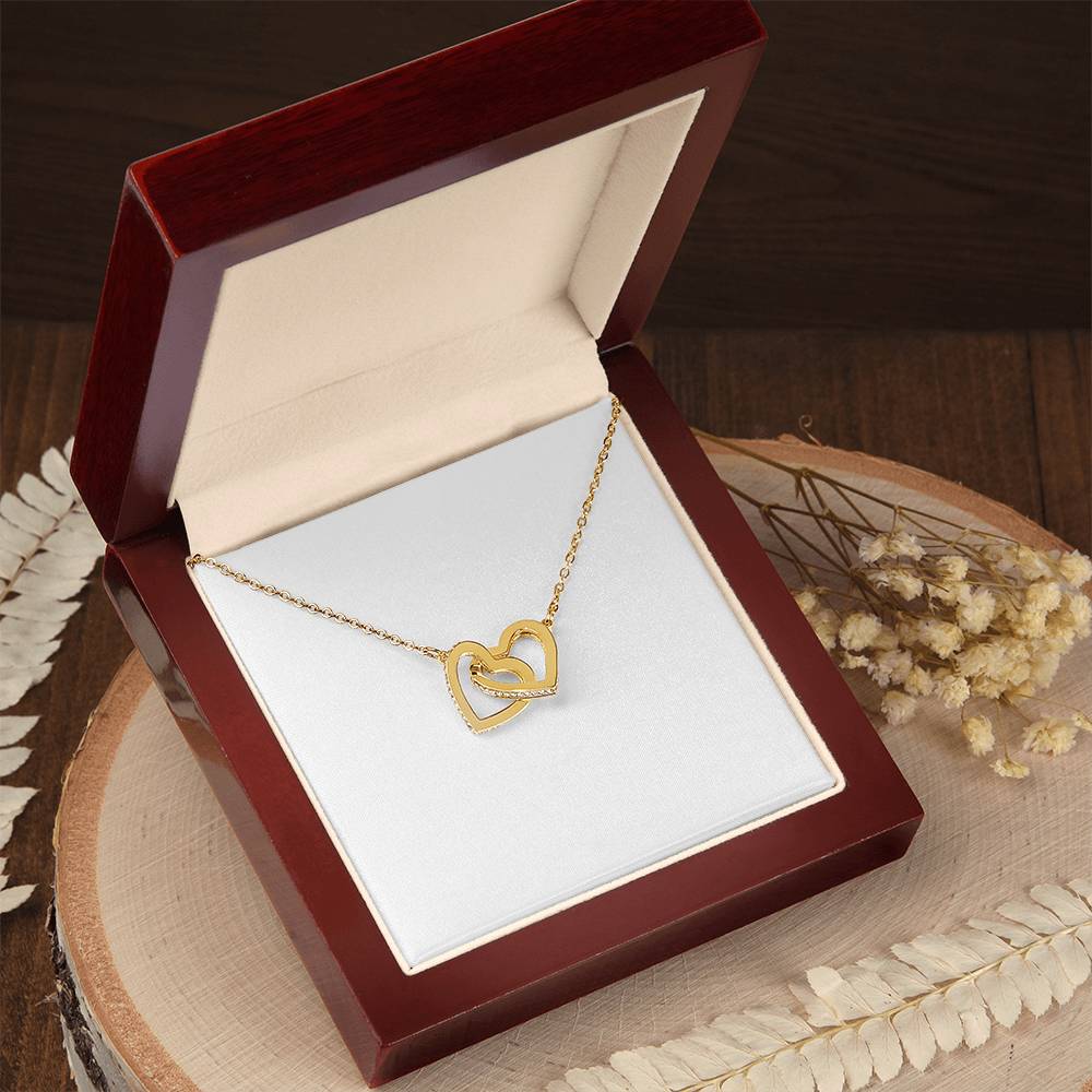 Interlocking hearts pendant necklace in yellow gold with chain on display