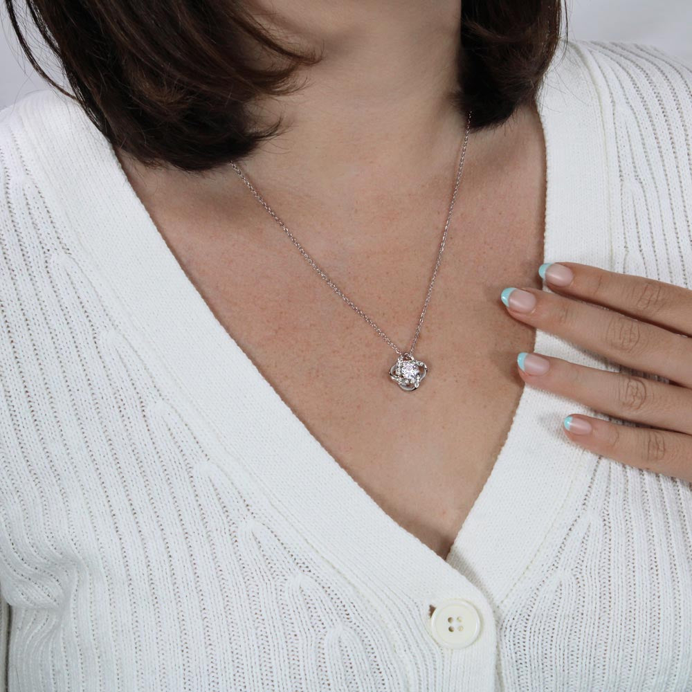 Silver love-knot pendant necklace with round clear gemstone and small halo accents
