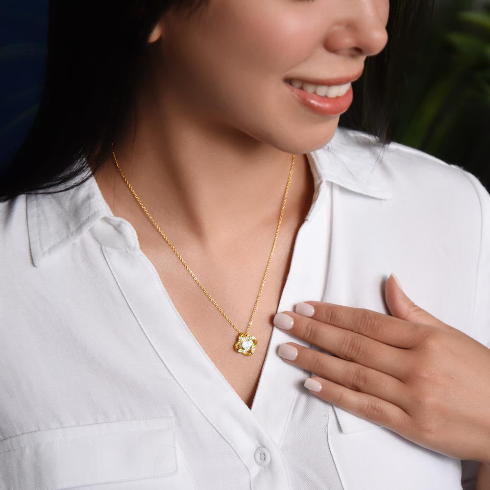 Gold love-knot pendant necklace with round clear gemstone and diamond halo, fine chain