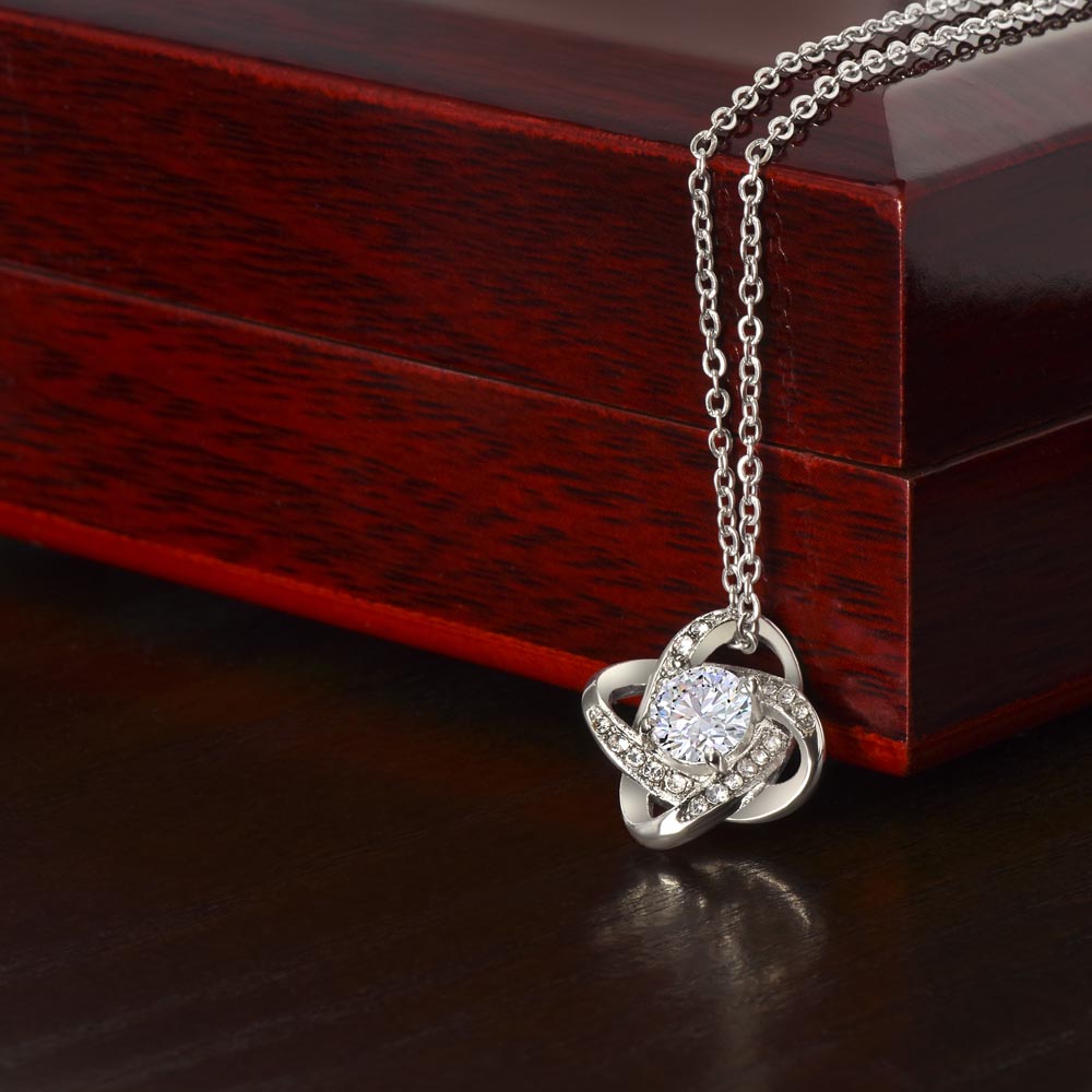 Silver love-knot pendant necklace with round clear center gemstone and diamond accents