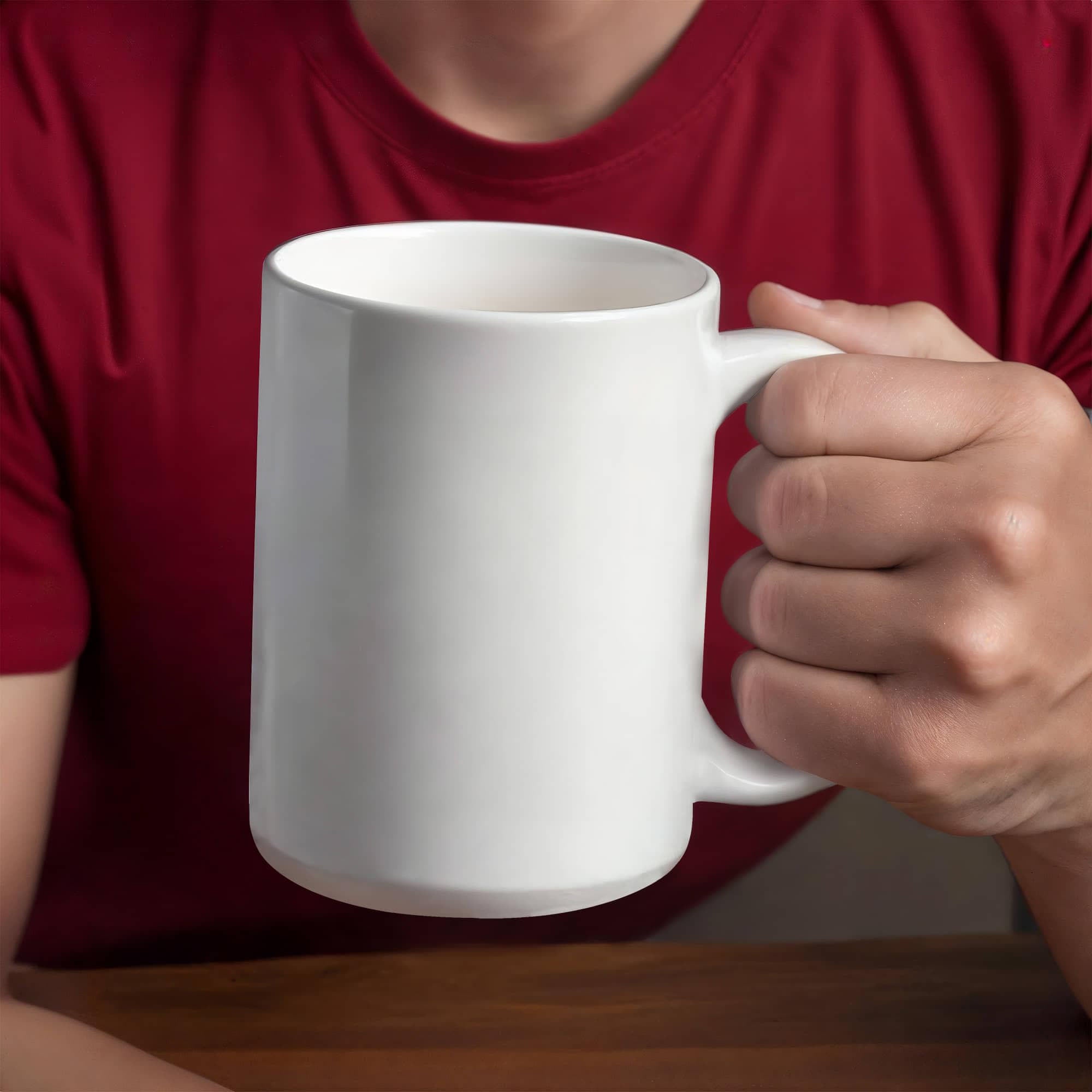 White ceramic mug held in a hand, glossy finish and curved handle