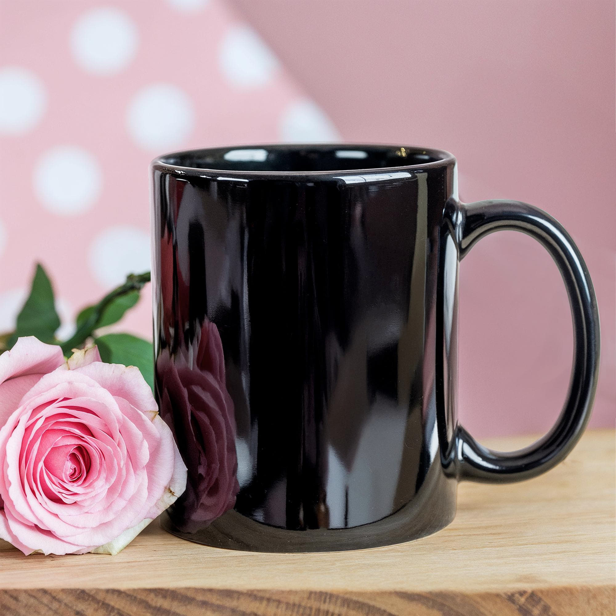 Black glossy ceramic mug with handle, close-up front view
