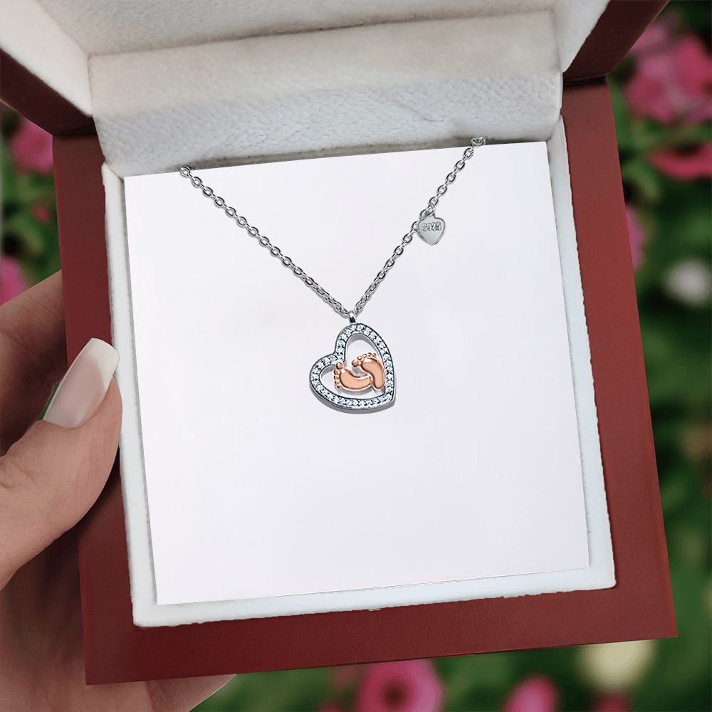 Heart pendant necklace with baby feet charm and tiny round medallion on chain