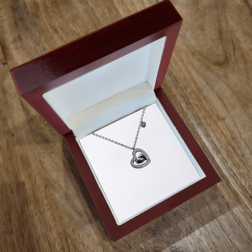 Heart pendant necklace with baby feet charm and small stone trim on silver chain