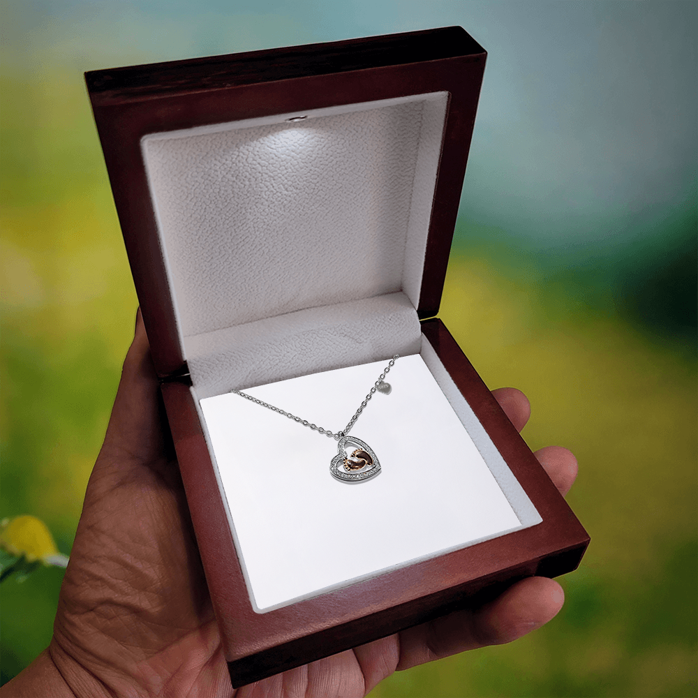 Silver heart pendant necklace with baby feet charm, set in sparkling border
