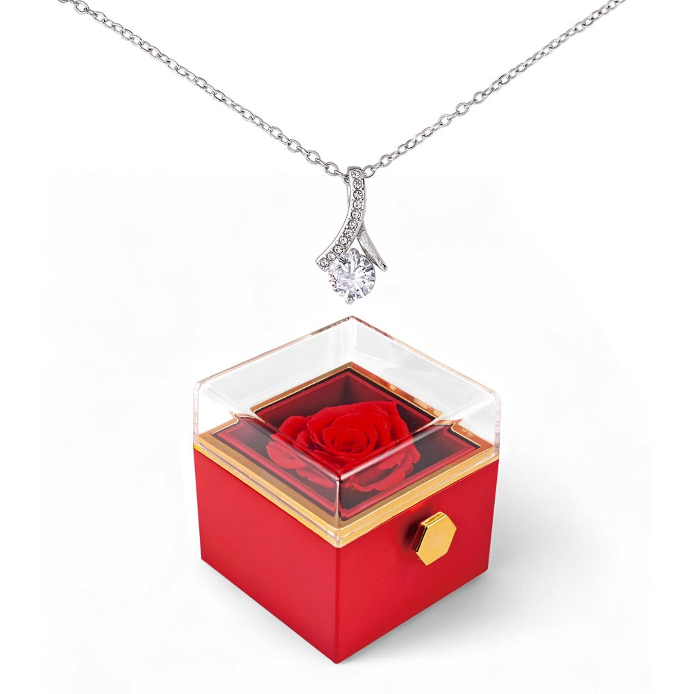 Silver-tone pendant necklace over red rotating rose gift box with gold trim