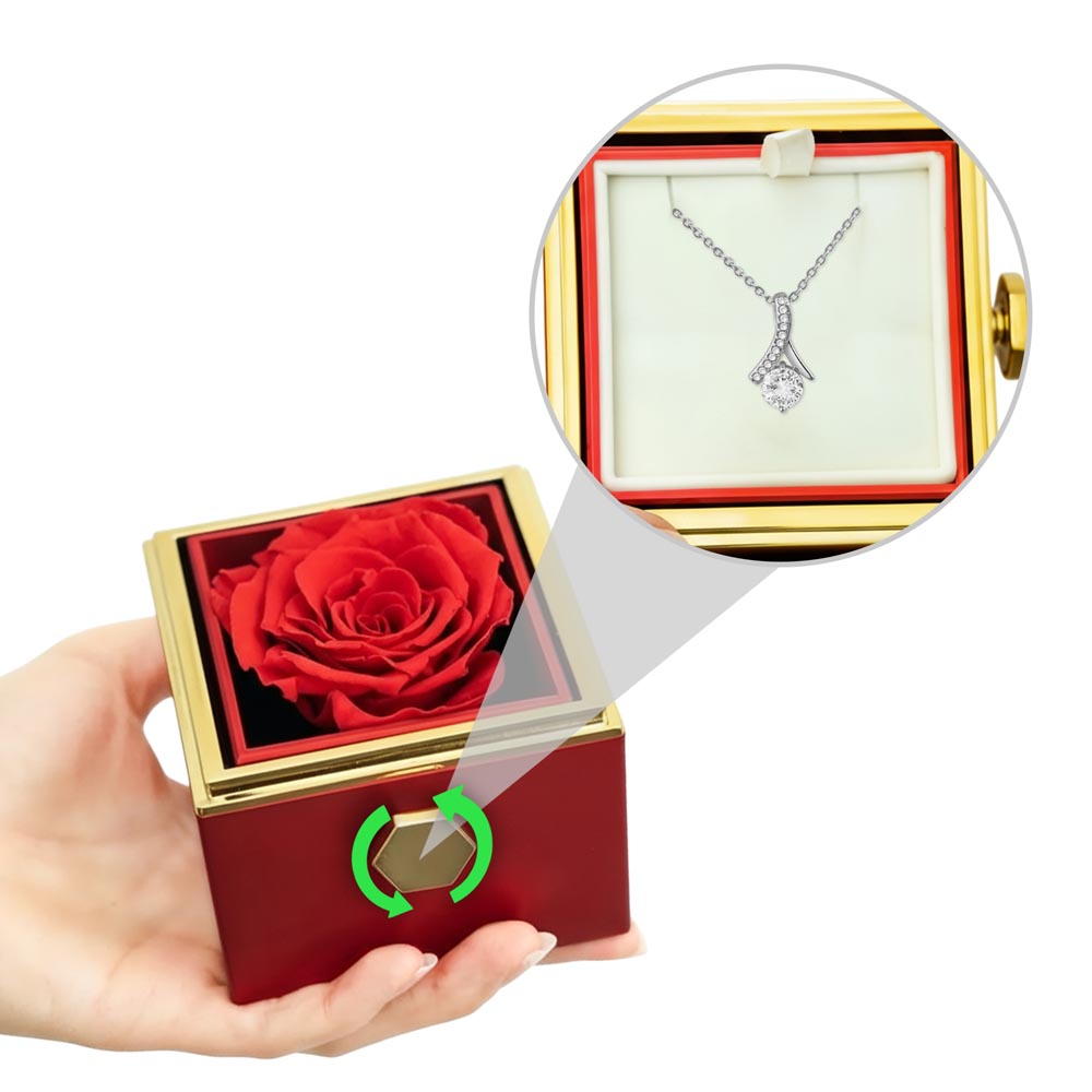 Red rotating rose gift box in hands, with silver-tone pendant necklace shown