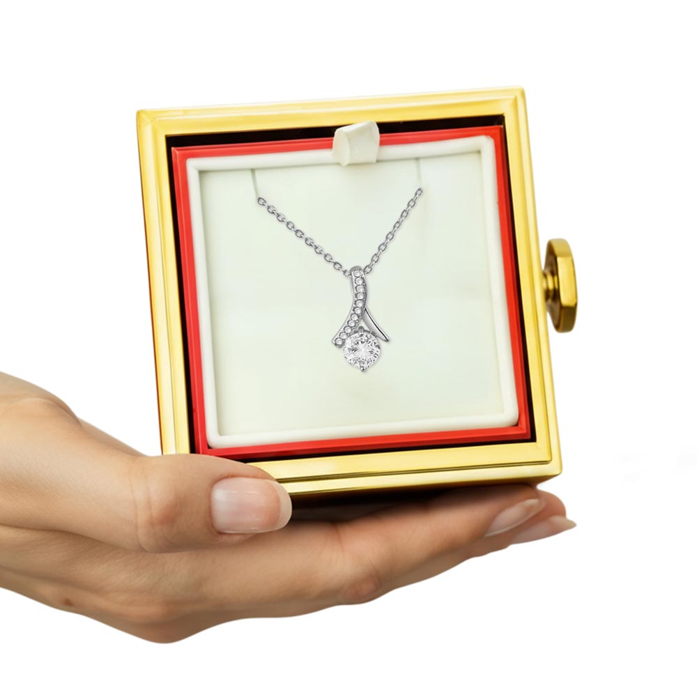 Gold-trimmed red gift box open with white insert and silver-tone pendant necklace